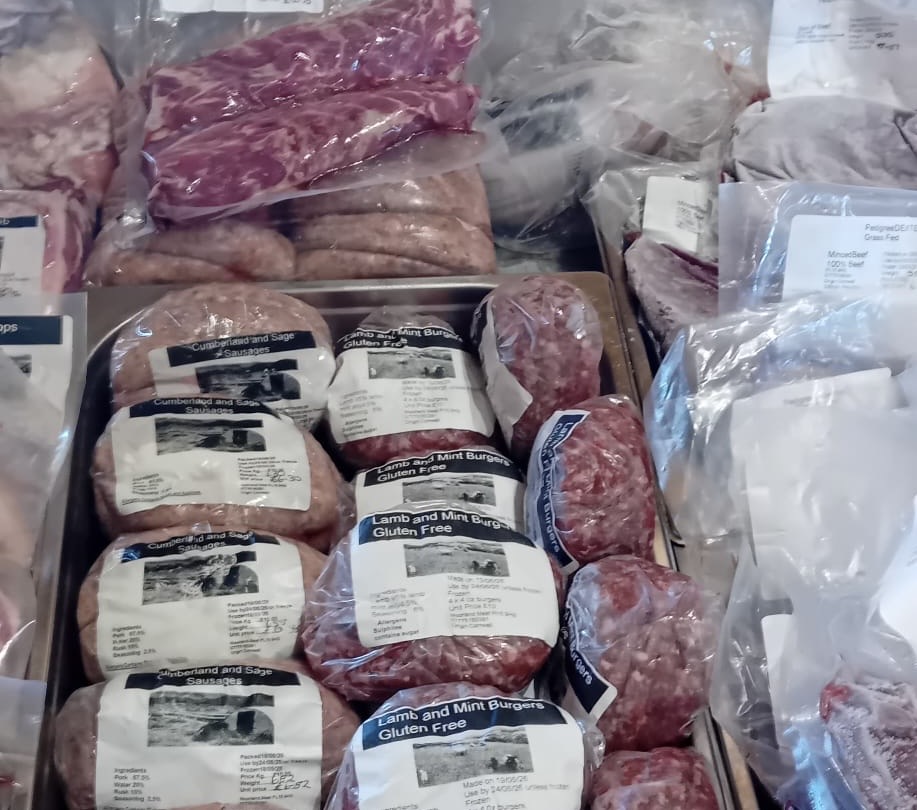 Farm shop display of Cumberland sausages, lamb burgers and fresh meat